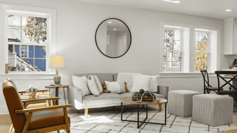 A bright modern living room featuring a slim-arm sofa on tall tapered legs, showcasing how elevation creates visual breathability in a compact floor plan.